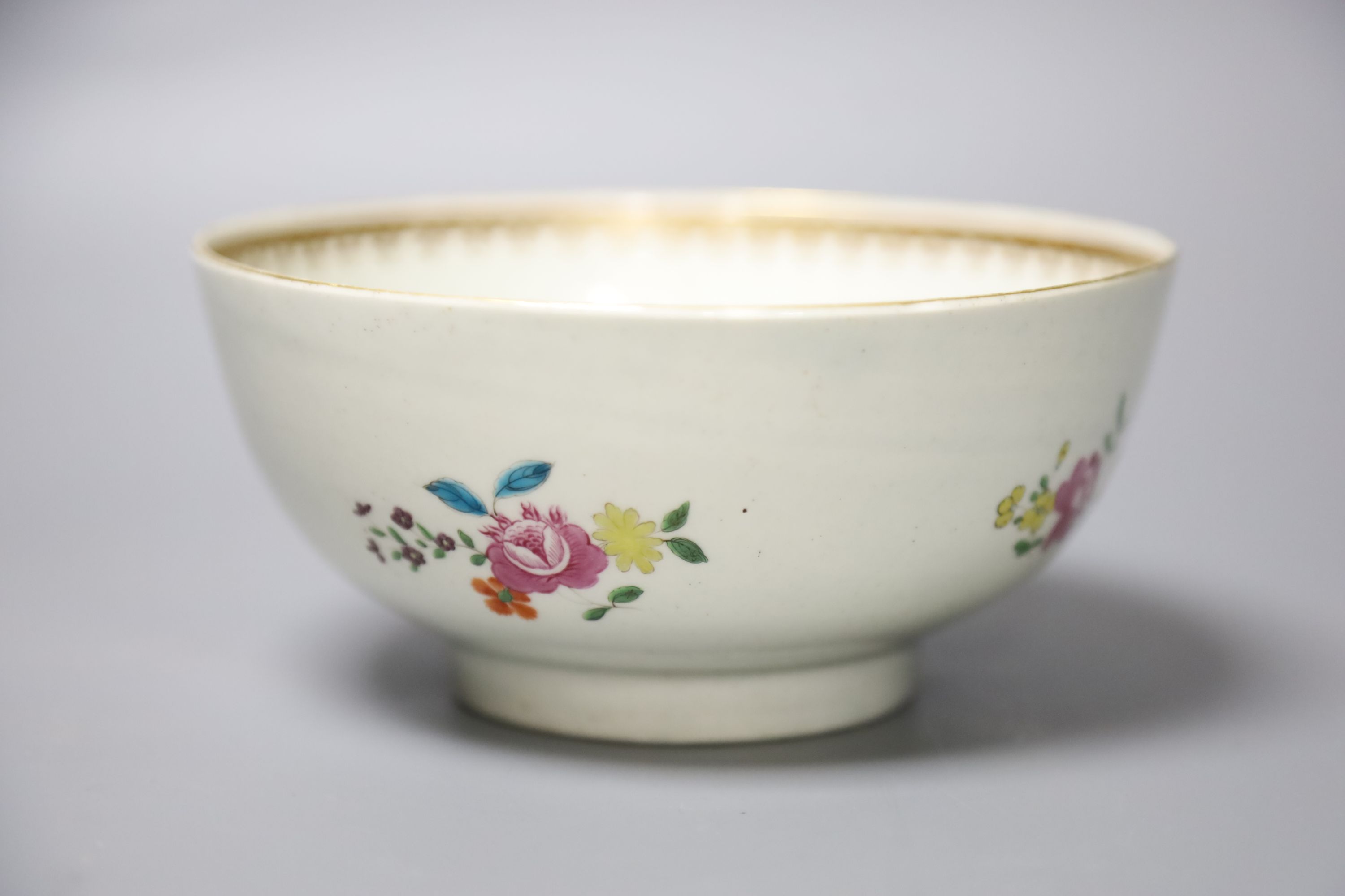 An 18th century Worcester bowl painted with coloured flowers gilded and outlined in red with initials, diameter 15cm